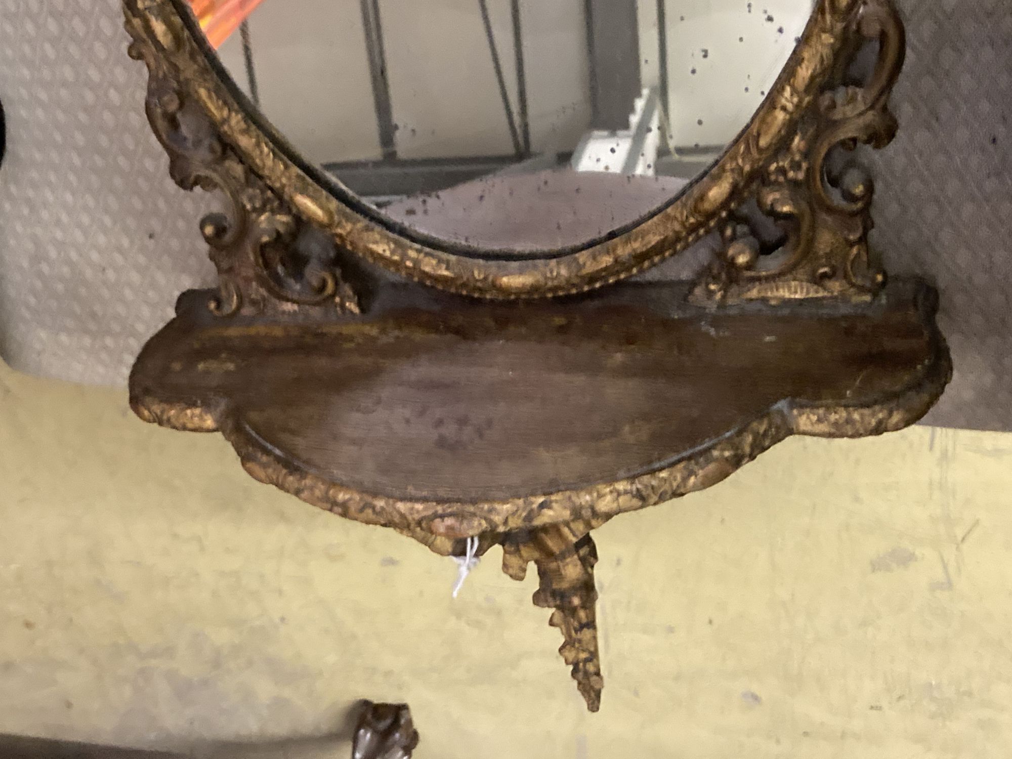 A Victorian oval giltwood and gesso mirrored wall bracket, width 38cm, height 78cm